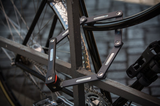 ABUS Bordo 5077 securing black bike to metal railing. #size_80cm