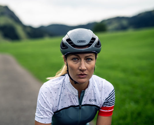 Female cyclist wearing race grey ABUS GameChanger helmet