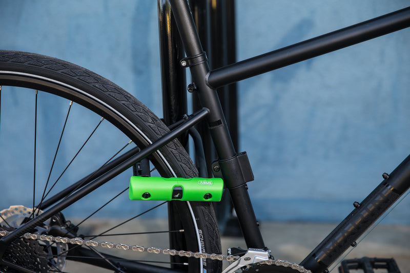 Load image into Gallery viewer, black bike secured to bike rack with ABUS Ultra 410 u-lock through rear wheel. #size_180mm
