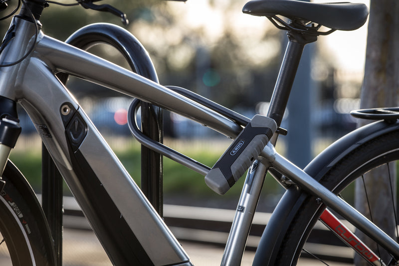 Load image into Gallery viewer, grey e-bike secured to rack with ABUS GRANIT XPLus 540 u-lock #size_230mm
