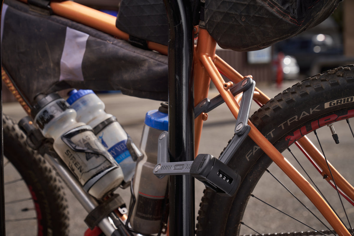 ABUS Bordo 6055C securing orange bicycle to rack #size_60cm