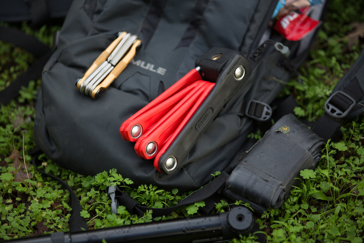 ABUS Bordo 6055 Mini sitting on back pack with muli-tool, pump and bike tube. 