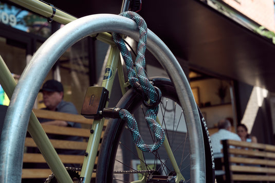 Bike secured to bike rack with crossing grey ACH chain and ABUS AlarmBox 2.0