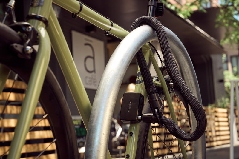 Load image into Gallery viewer, bike secured with black ACH Chain and ABUS AlarmBox 2.0 #color_black

