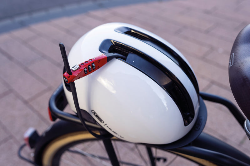 Load image into Gallery viewer, Combiflex TravelGuard in red securing white ABUS Helmet to rear rack of bicycle #color_red
