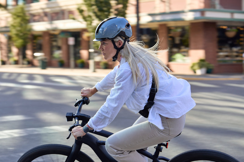 Load image into Gallery viewer, cyclist riding through cityscape wearing race grey ABUS HUD-Y helmet #color_race grey 
