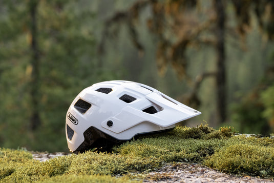 white MoDrop MIPS sitting on mossy trail