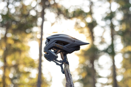 Black ABUS CliffHanger MIPS sitting on top of stump