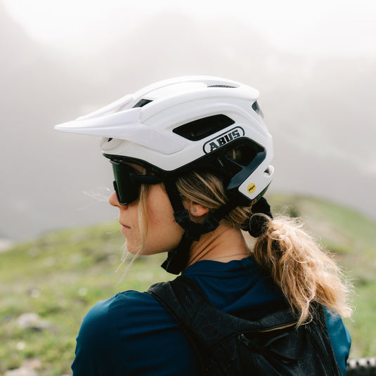 side shot of woman wearing white ABUS CliffHanger MIPS helmet