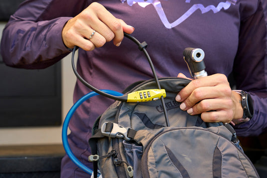 person pulling yellow CombiFlex TravelGuard from hydration pack