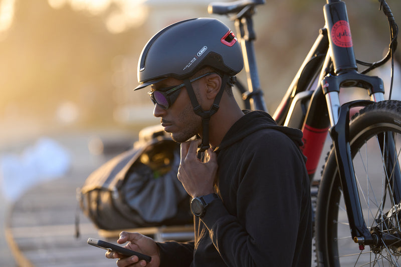 Load image into Gallery viewer, cyclist sitting next to bicycle wearing Titan ABUS HUD-Y helmet #color_titan
