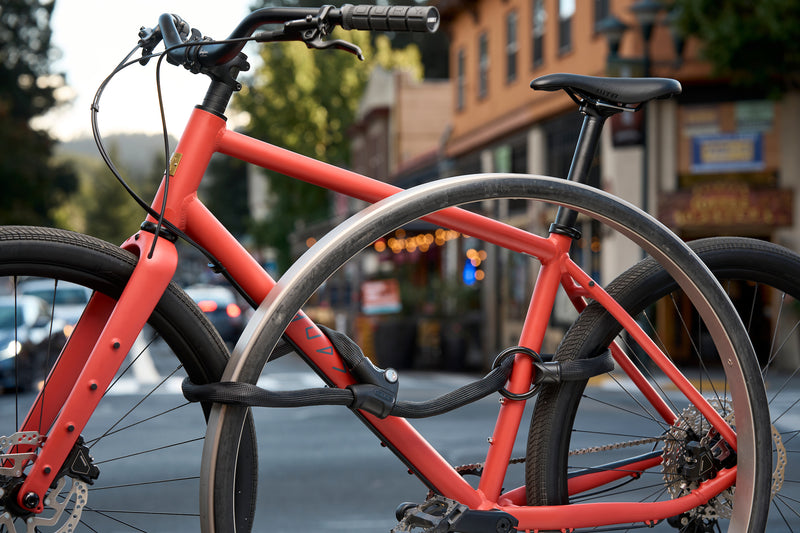 Load image into Gallery viewer, Infinity loop securing orange bicycle and wheels to rack in downtown setting  #color_black
